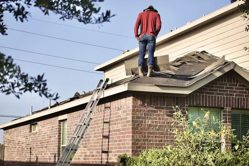 Professional roofer working on a residential roof in Hinmansville